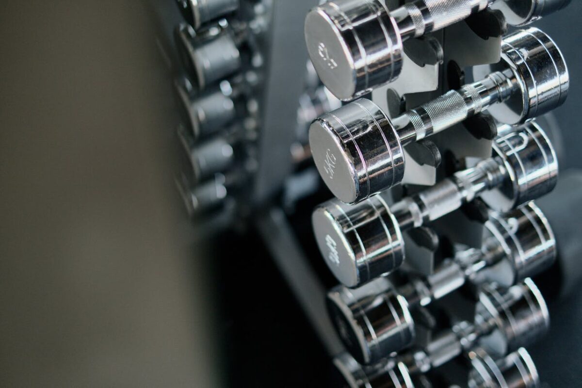 Close-up of chrome dumbbells neatly arranged on a rack in a modern fitness gym.